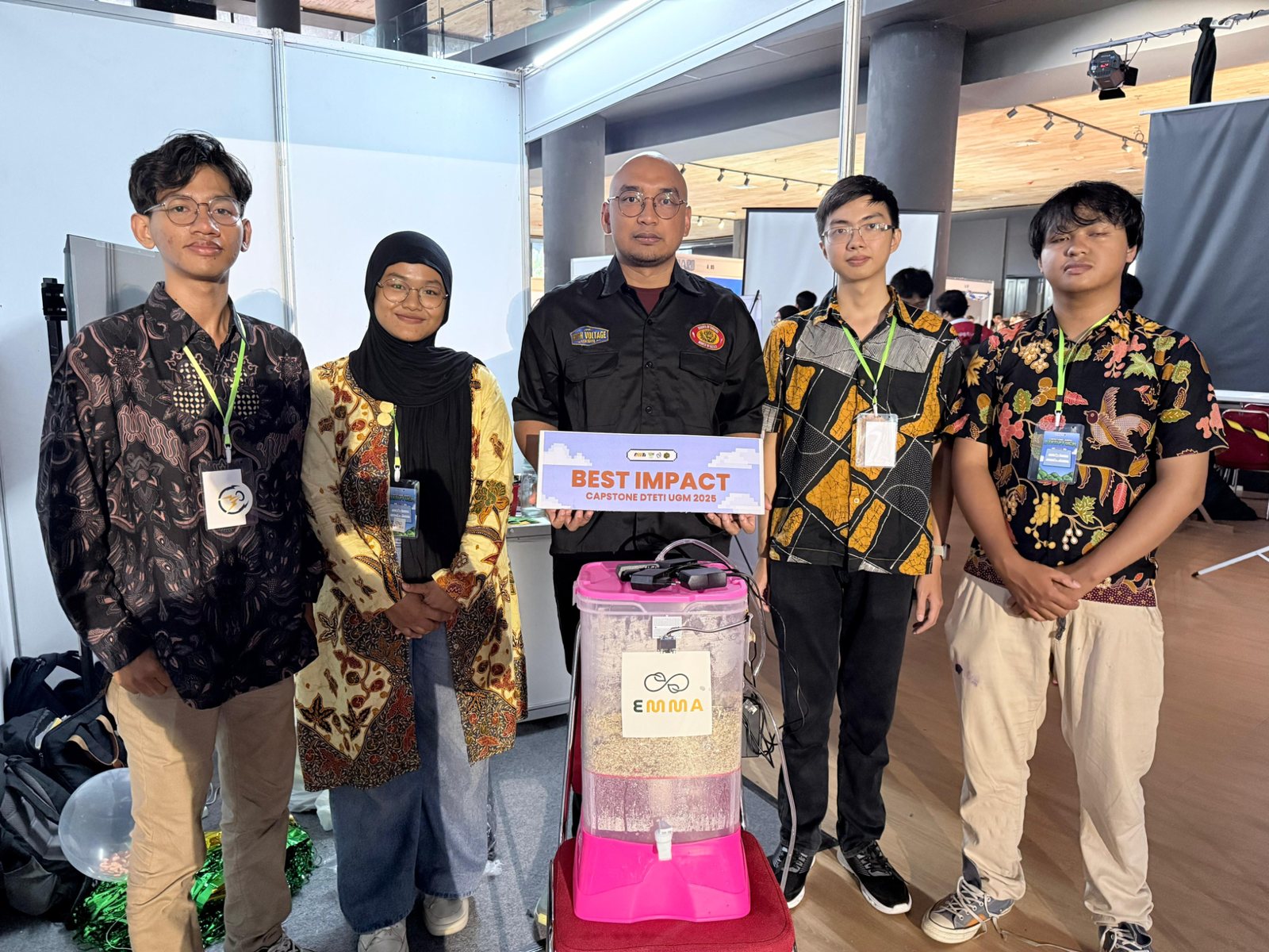 EMMA Smart Composting team at Capstone DTETI UGM 2025 holding the Best Impact award beside the prototype